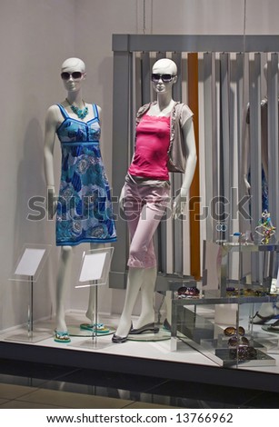 store window with dressed mannequins in shopping mall