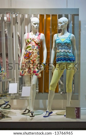store window with dressed mannequins in shopping mall
