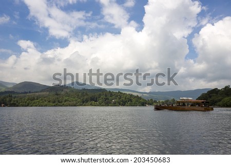 KESWICK, ENGLAND - JUNE 13: Group of tourists at Lake Derwentwater in Keswick, England on June 13, 2013. Lake Derwentwater is part of the famous Lake District in England.