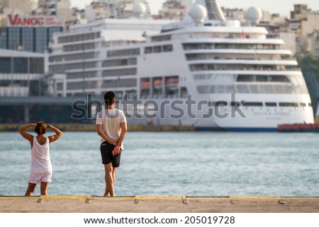 Athens, Greece - June 29: Unidentified people watching a cruise ship departing from Piraeus, a port in Athens, Greece on June 29, 2014.