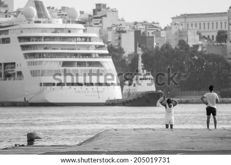 Athens, Greece - June 29: Unidentified people watching a cruise ship departing from Piraeus, a port in Athens, Greece on June 29, 2014.