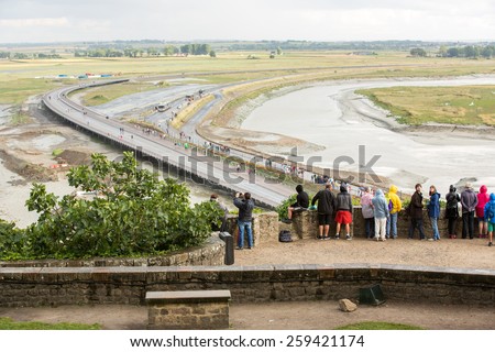 Mont Saint Michel, France - August 12: View of the road leading to Mont Saint Michel, France during a high tide on August 12, 2014.