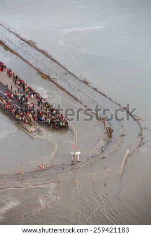 Mont Saint Michel, France - August 12: View of the road leading to Mont Saint Michel, France during a high tide on August 12, 2014.