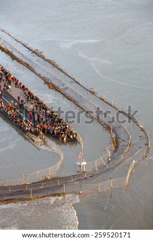 Mont Saint Michel, France - August 12: View of the road leading to Mont Saint Michel, France during a high tide at sunset on August 12, 2014.