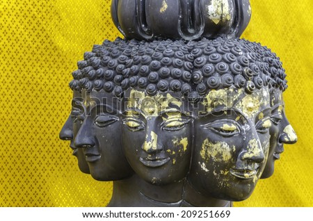 Many face of Buddha statue against golden background