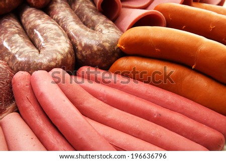 A collection of cold meats, bologna, sausages and boerwors on an isolated white studio background