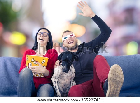 Couple with dog on the couch watching TV