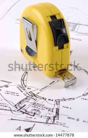 A yellow measuring tape on a architectural plan