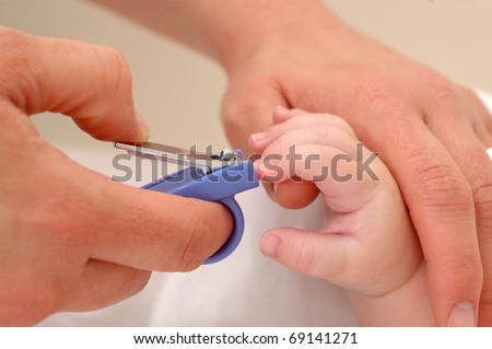 Close up of mum cutting babies nails