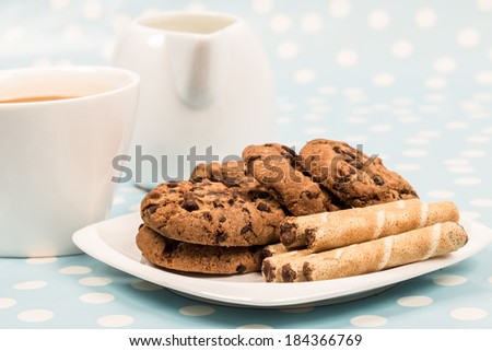 coffee with chocolate cookies and rolls wafer with hazelnut on retro blue with white dots background