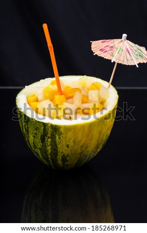 fresh cocktail with fresh fruits in watermelon on the black background