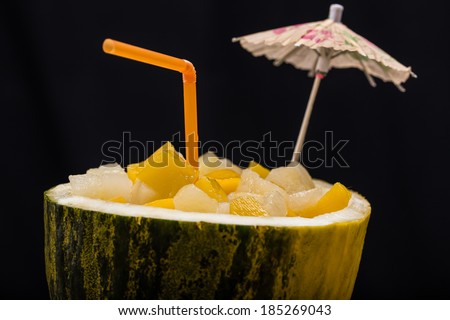 fresh cocktail with fresh fruits in watermelon on the black background