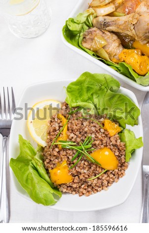 buckwheat and chicken with yellow pepper and lettuce on diner table in food tray