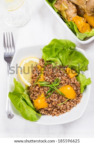 buckwheat and chicken with yellow pepper, lemon and lettuce on diner table in food tray