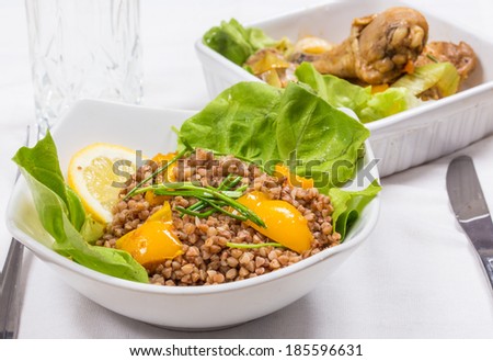 buckwheat and chicken with yellow pepper lemon and lettuce on diner table in food tray