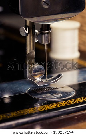 Vintage retro sewing machine with sewing equipment on a black background