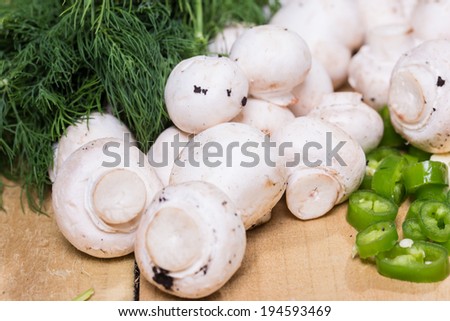 sliced green chili pepper with button mushrooms and dill weed  on the wooden background