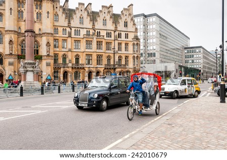 LONDON, ENGLAND - SEPTEMBER 15, 2013: Men on motor tricycle on the road in London city.