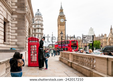 LONDON, ENGLAND - SEPTEMBER 15, 2013: Street artist perform in front of a red phone booth with the Big Ben in background