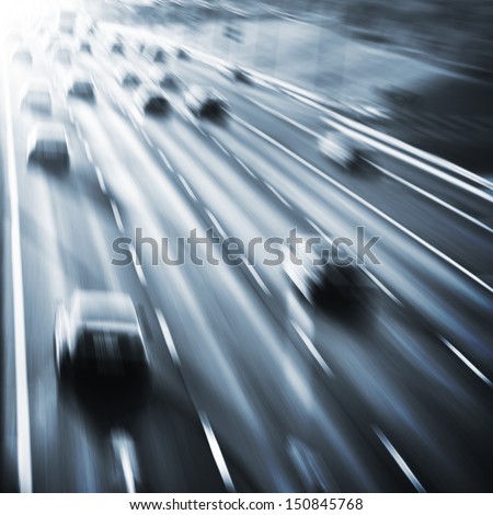 Cars in motion blur on the road at dusk.