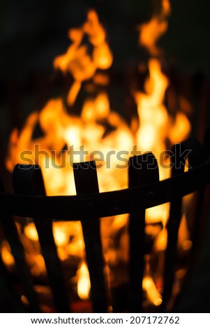 A fire in a fire basket, slightly tilted, fire is out of focus