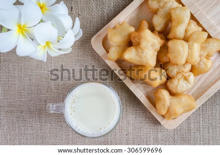 Top view Soybeans and soy milk in a glass with fried bread stick .