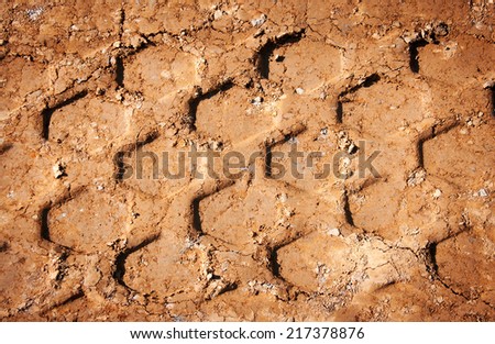 close up wheel\'s trail tread in the red mud as a background