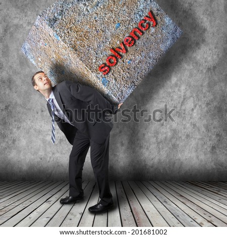 Businessman carrying heavy package - concept of tough career in the business