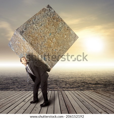 Businessman carrying heavy package - concept of tough career in the business