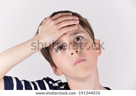 Young boy slapping hand on head in an oh-no moment