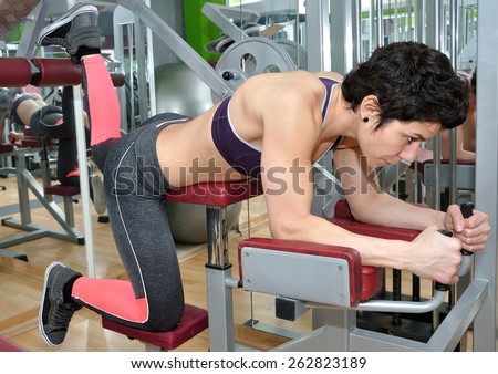 Woman with short black hair training in a gym
