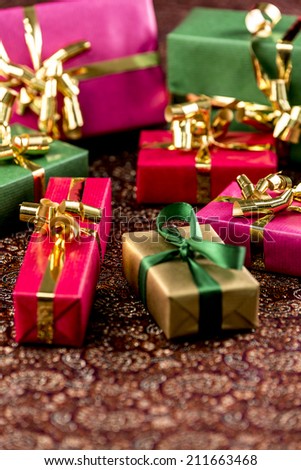 Seven wrapped gifts placed on a festive cloth. Background for any gift-giving occasion. Shallow depth of field.