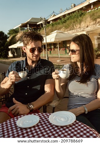 Young people relaxing with cup of coffee outside the cafe