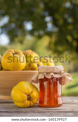 Quince jelly in jar with fruit, outdoors