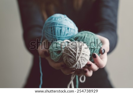 Hands holding a balls of yarn