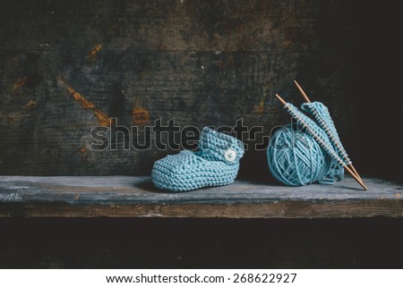 Knitting baby shoes with blue yarn