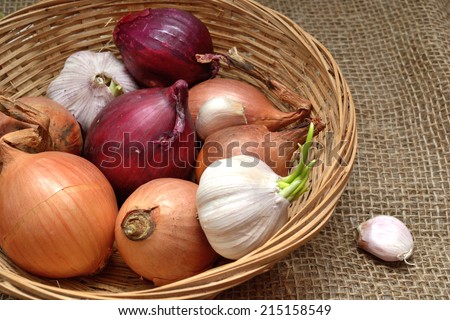Bulb onion white onion, red onion and garlic in a wicker basket