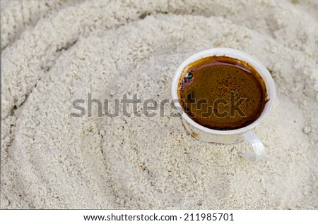 one cup with coffee costs on sand