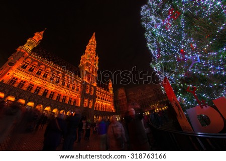 Christmas tree in the middle of red-illuminated Grand Place, the focal point of Brussels, Belgium