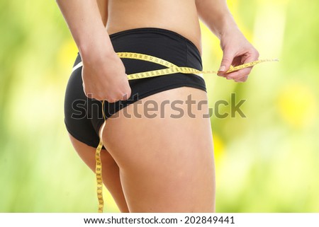 woman measuring her hip with measuring tape
