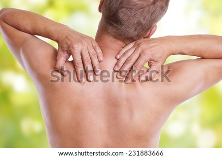 man has pain in the neck in front of green background
