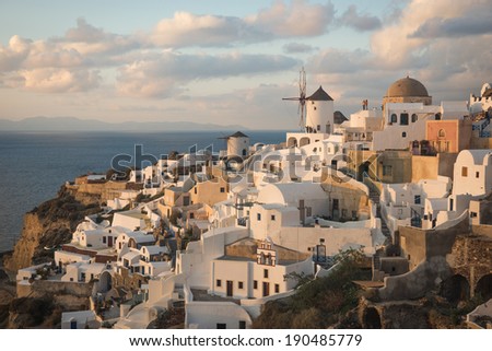 White city on a slope of a hill at sunset, Oia, Santorini, Greece