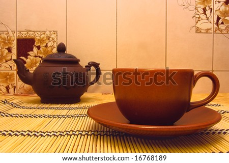 China teapot, cup and saucer on wooden support