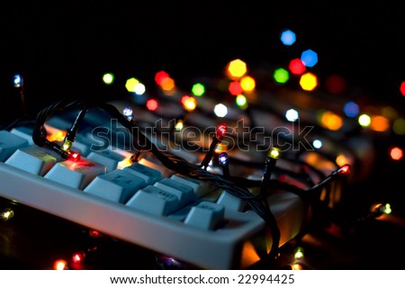 Say no to work on holidays: computer keyboard corded with electric color garland lights