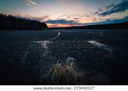 Thawed, dirty ice in the spring on lake, Ural Mountains, Russia