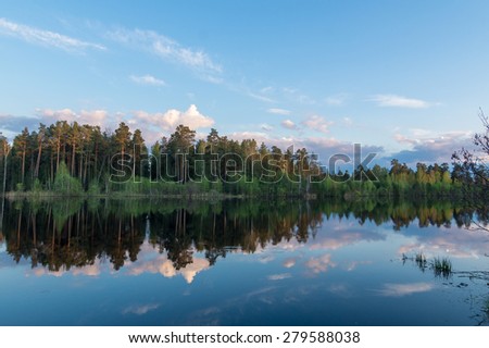 Evening lake with wood reflexion in water, Russia, Ural Mountains