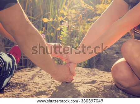 a couple holding hands in the rays of sunlight during sunrise or sunset with copy space with a retro instagram toned filter