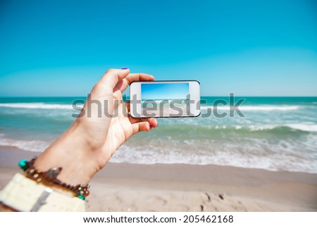 Girl resting and photographed beach and sea on your mobile phone