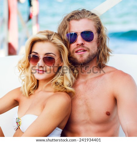 Happy young beach couple closeup portrait outdoors in sun. Young people wearing sunglasses eyewear. Athletic handsome man and young pretty woman smiling  and enjoy summer.