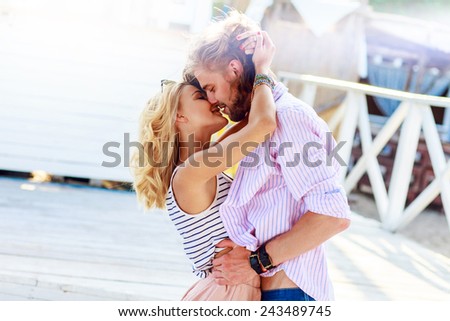 Young pretty woman kissing attractive handsome guy .Man cuddles his girlfriend. Sensual photo.